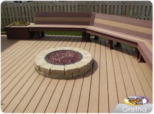 A low maintenance deck with a bench and fire pit built in